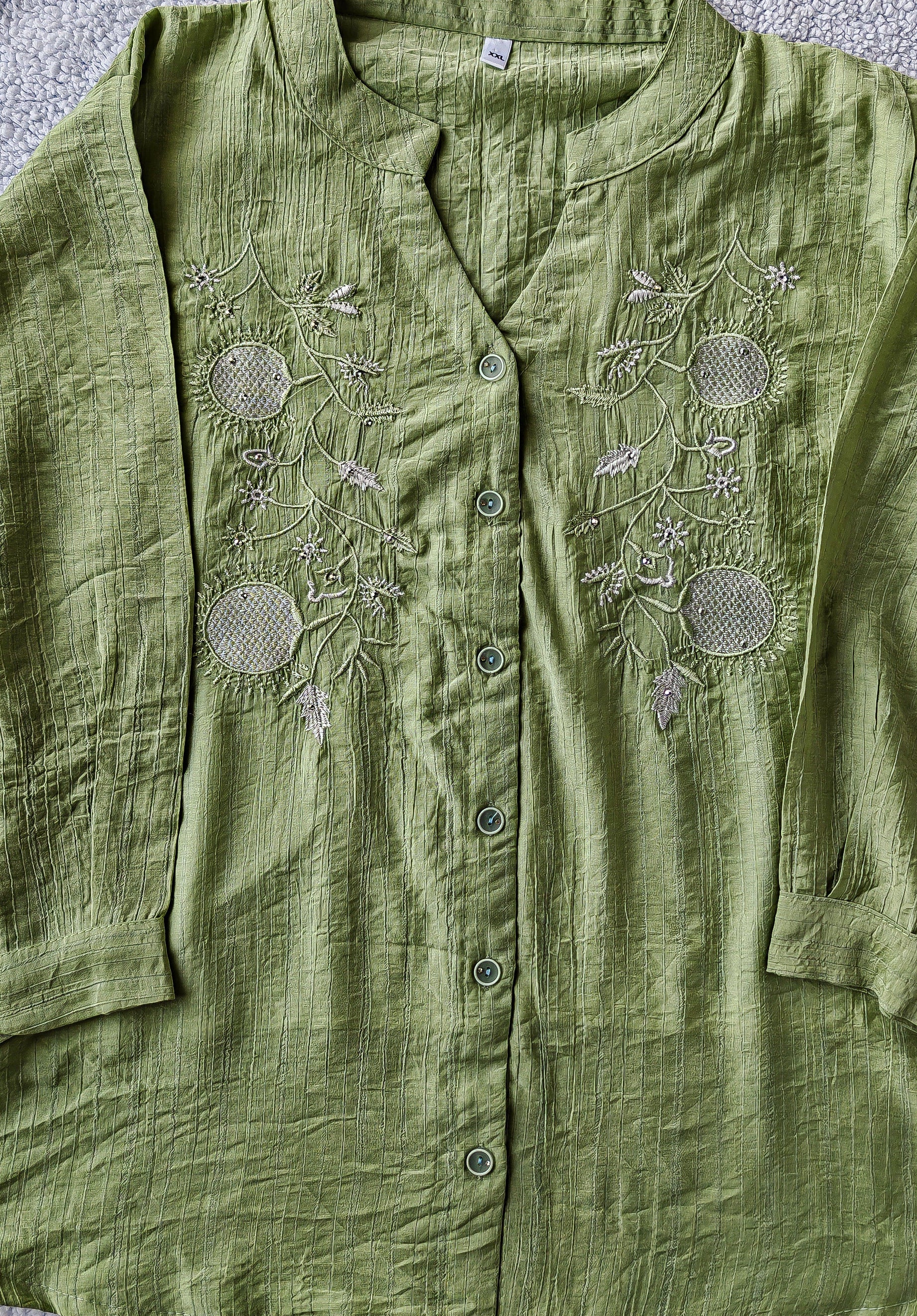 Close up of green embroidered mandarin collar women's blouse