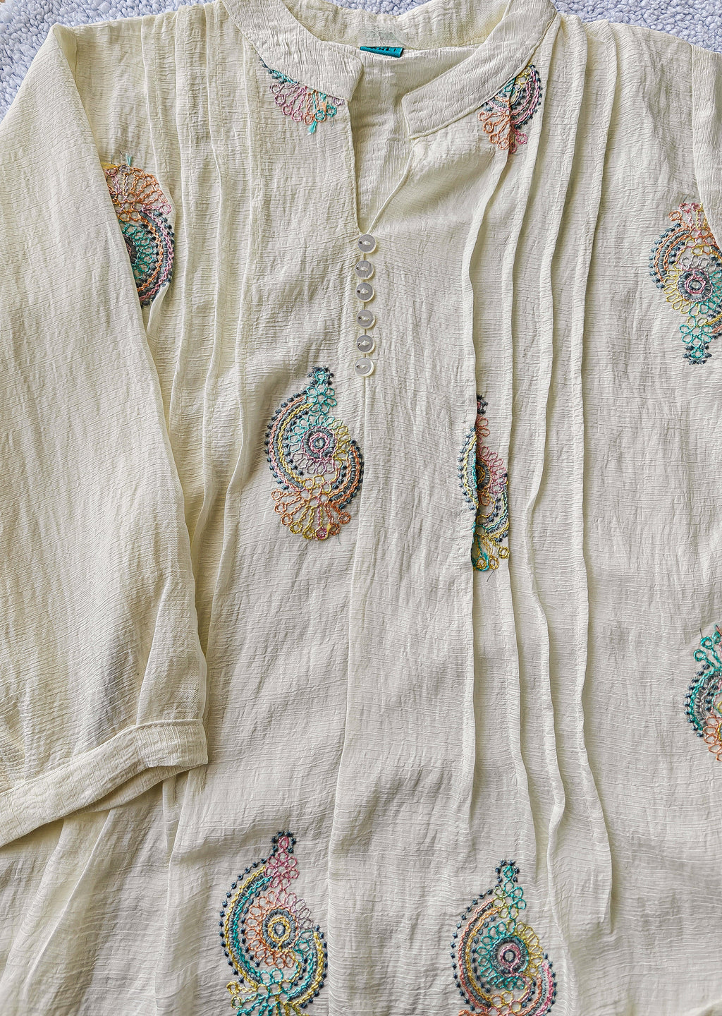 close up of white blouse with colorful embroidery 
