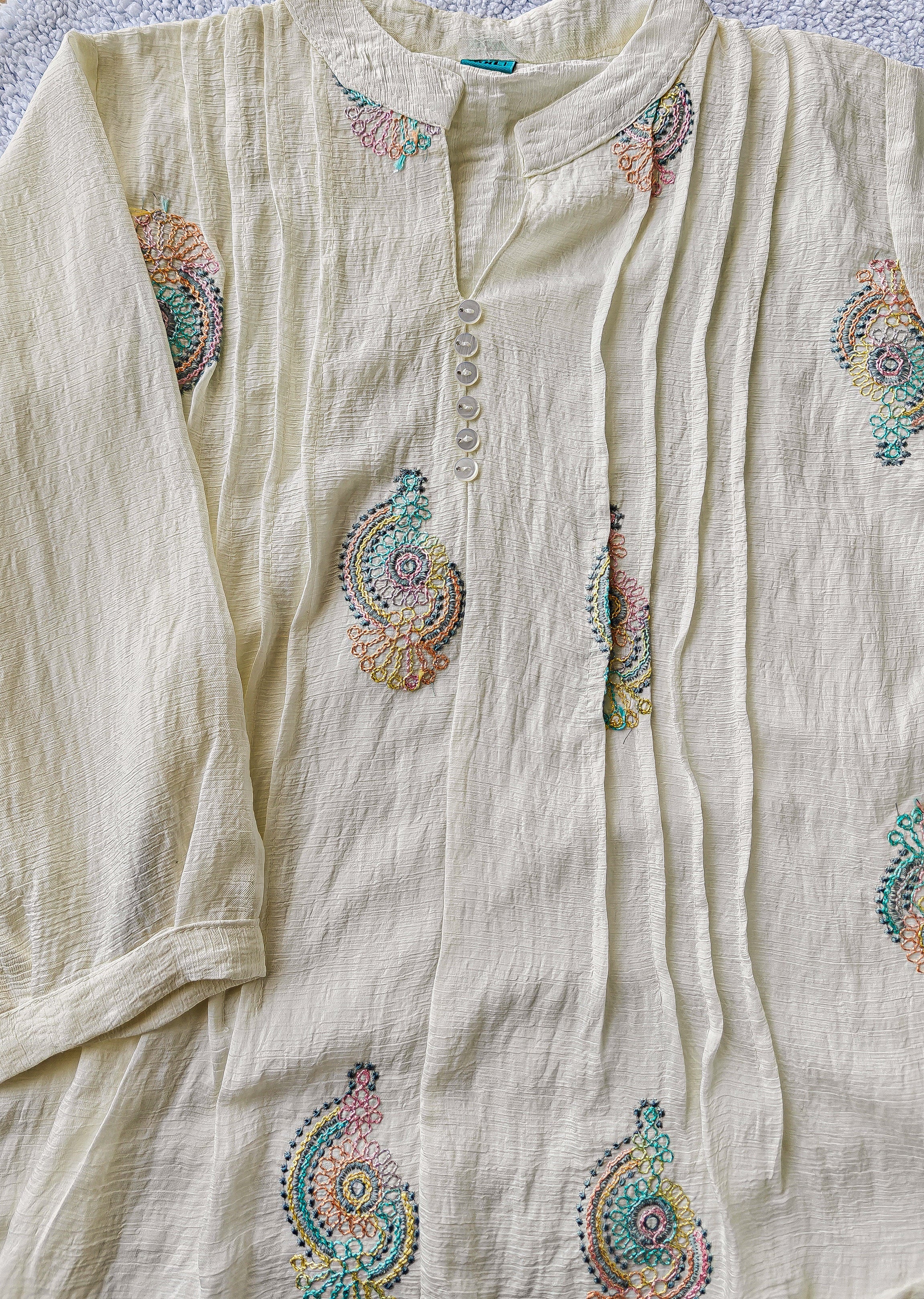 close up of white blouse with colorful embroidery 