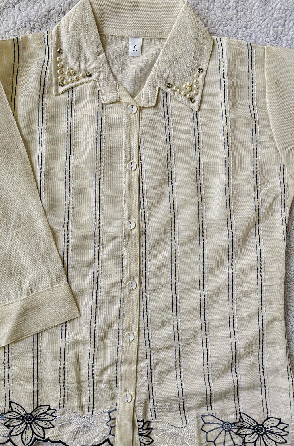close up of white striped shirt with floral detailing