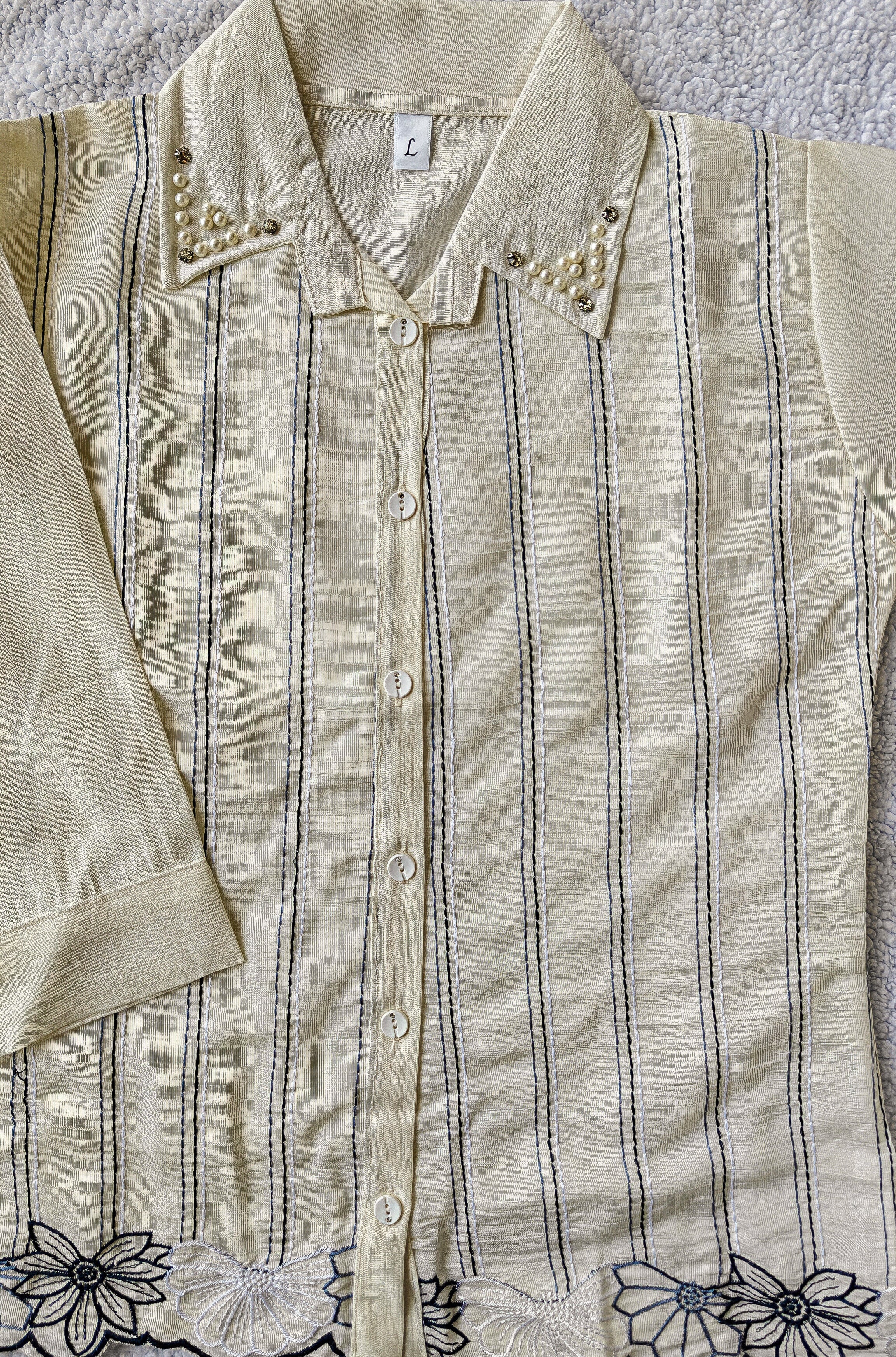 close up of white striped shirt with floral detailing